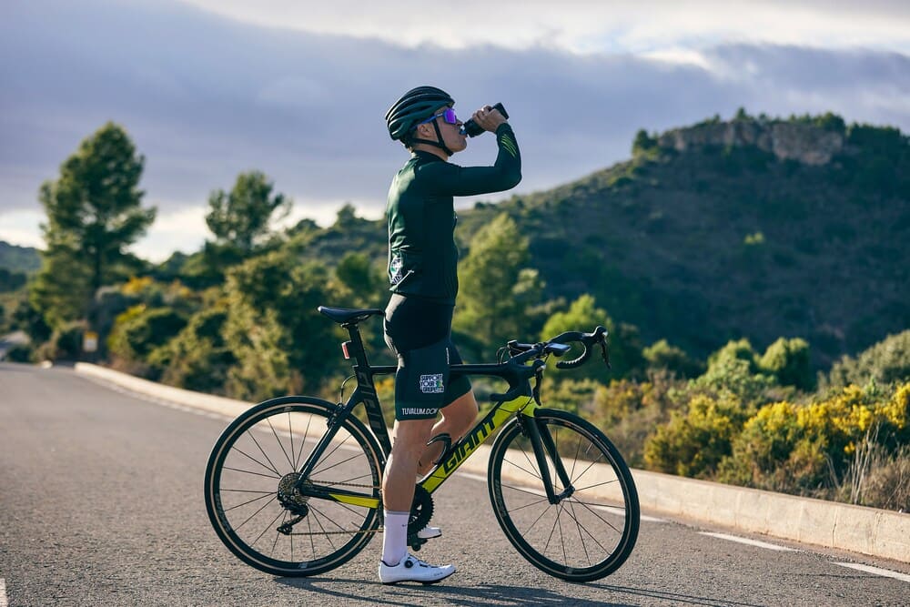 Cyclist is drinking water.